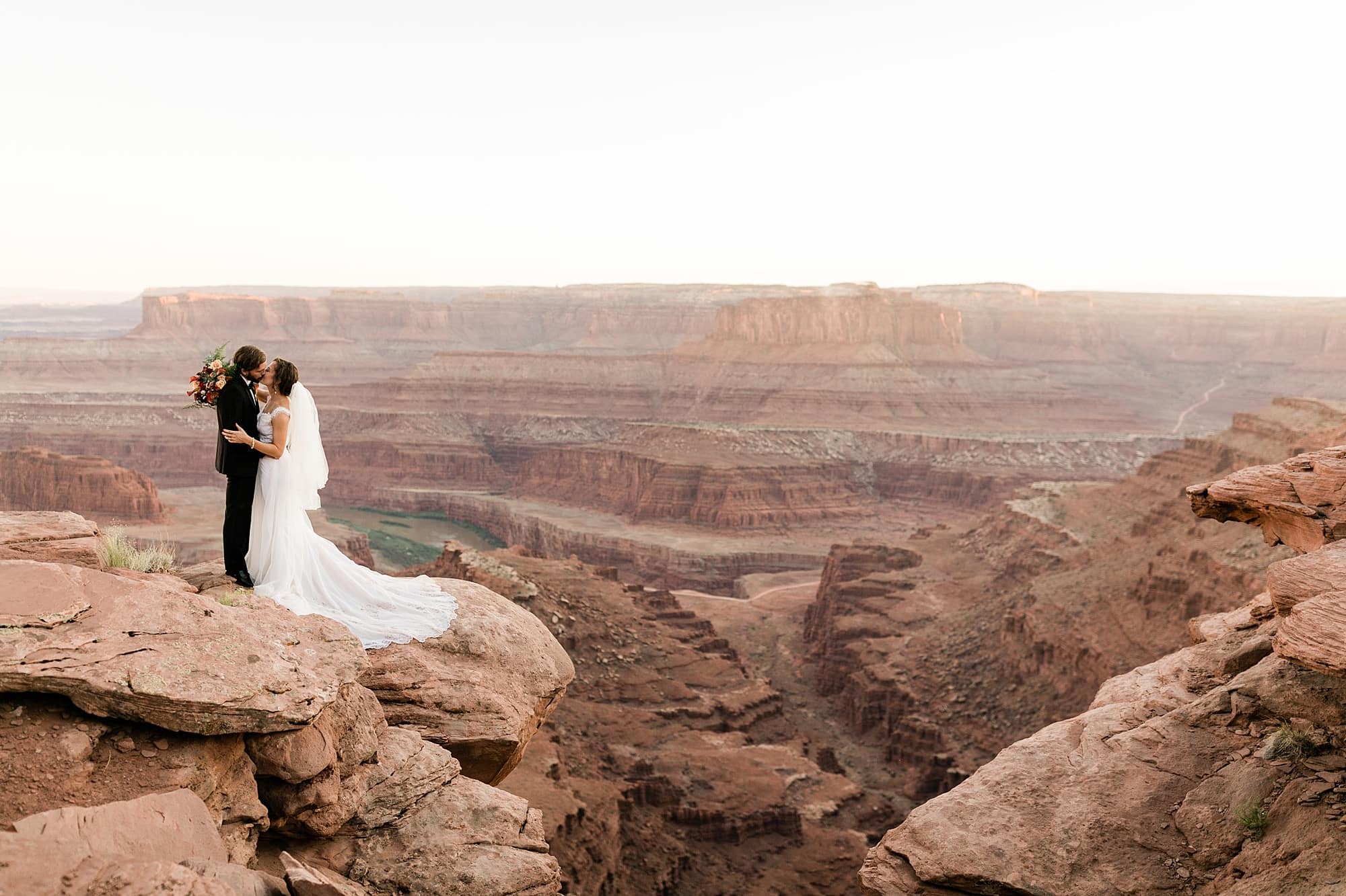 A couple kisses after they elope in Moab at Dead Horse Point.