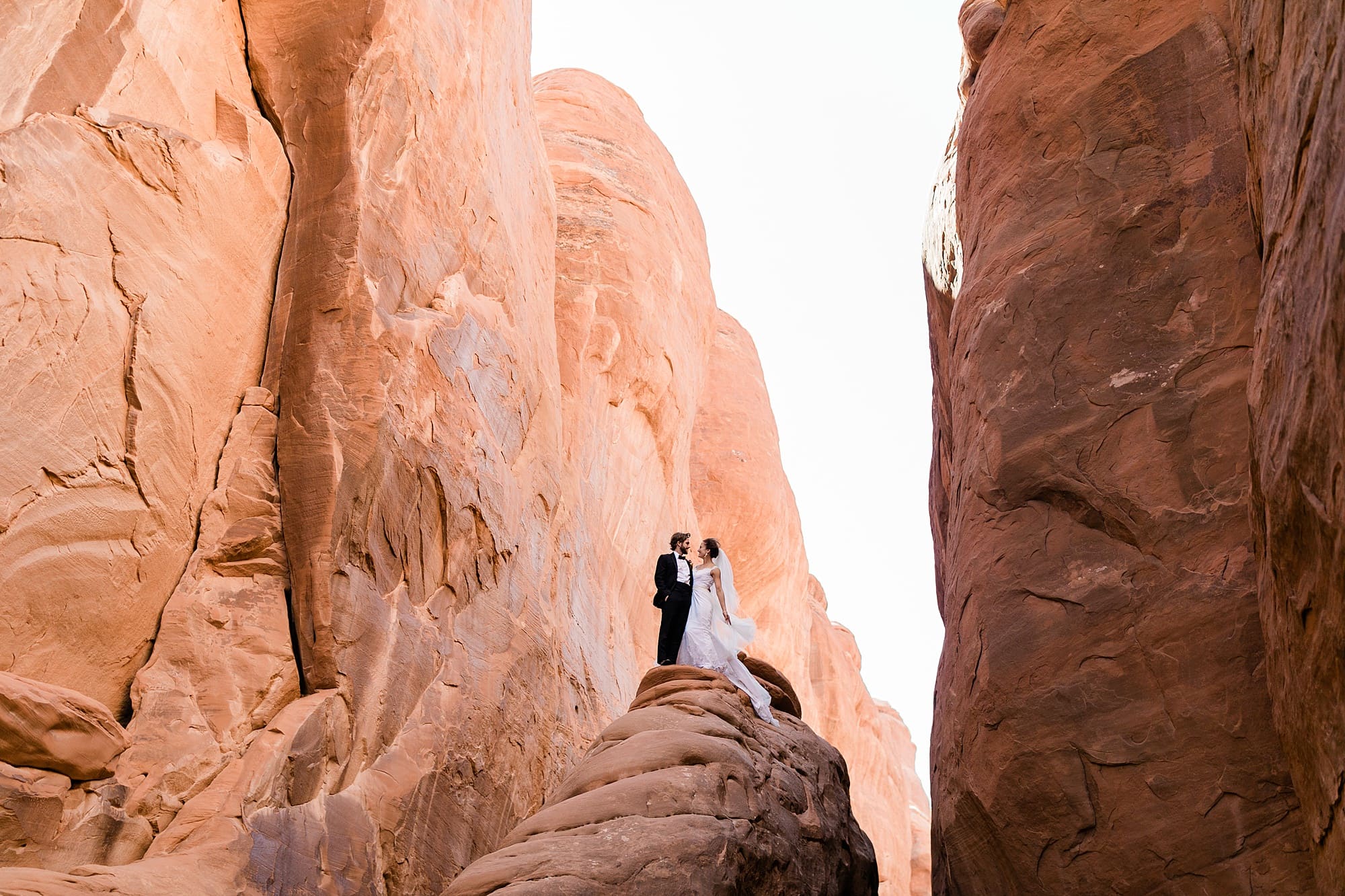 A couple poses in wedding attire after they elope in Moab.