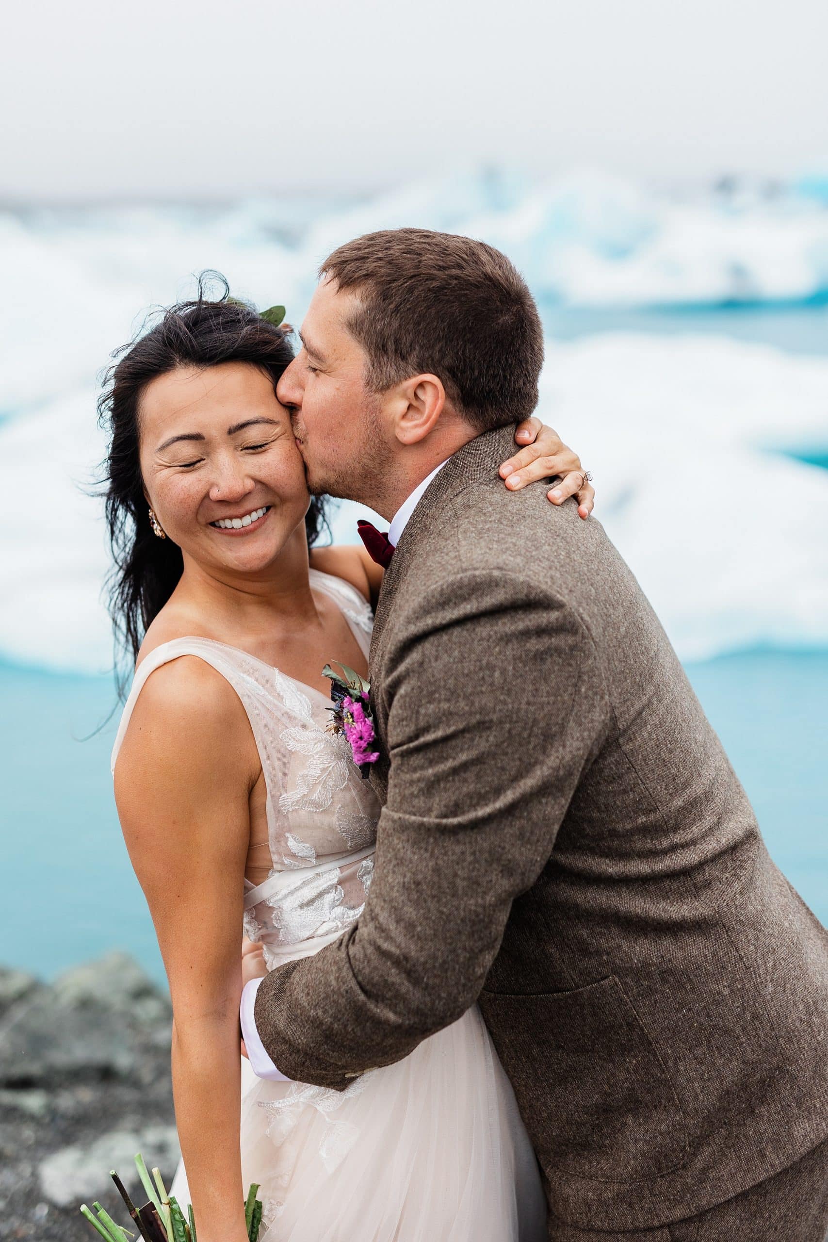 A couple kisses after they elope in Iceland near icebergs