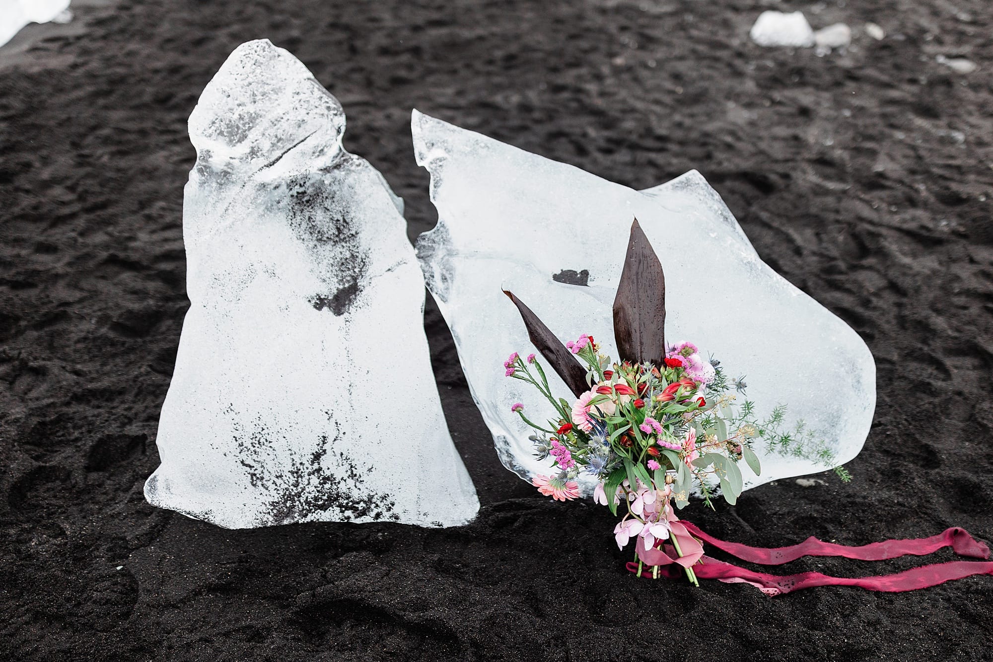 A bridal bouquet lies near pieces of ice on Diamond Beach in Iceland 