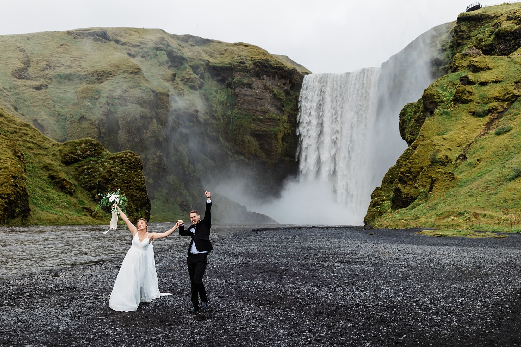 A couple celebrates their elopement near Skógafoss in Iceland