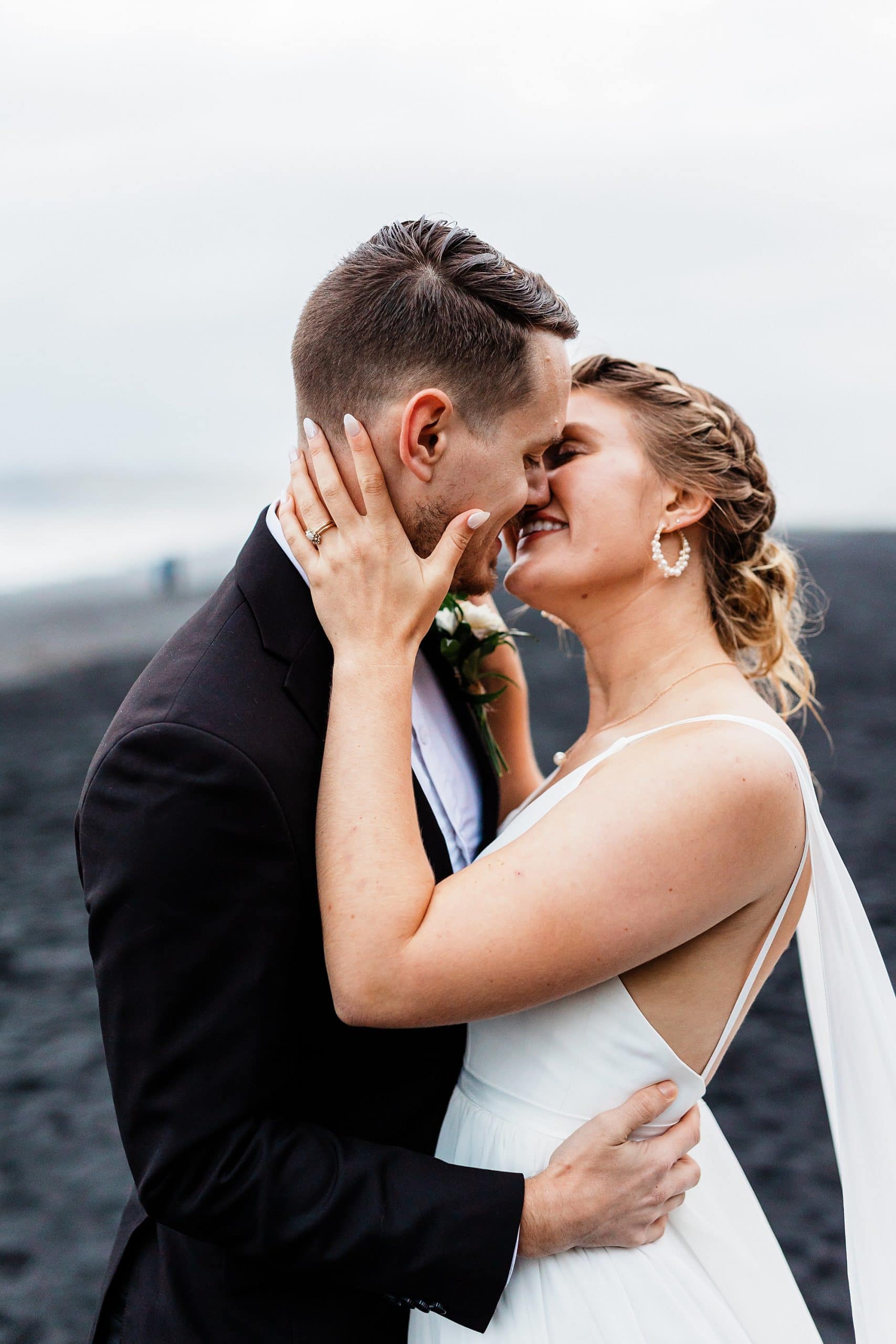 A newly married couple kisses on Iceland's Black Sand Beach