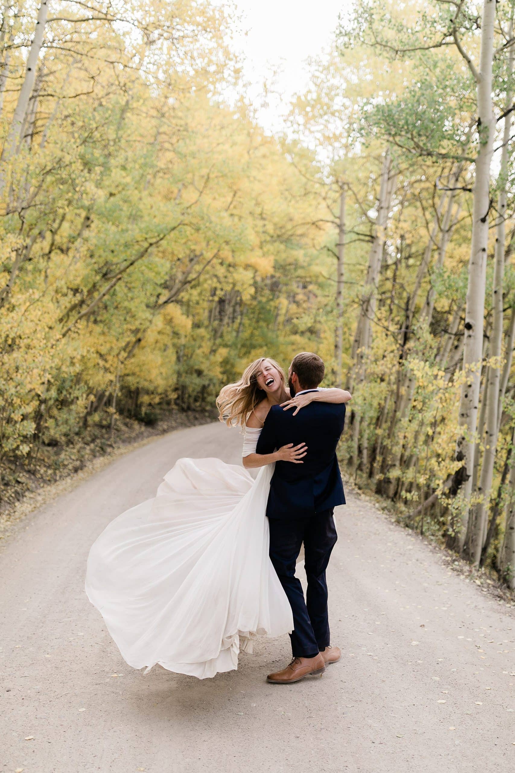 Newlyweds spin in excitement after their elopement in Colorado on trail near aspen trees 