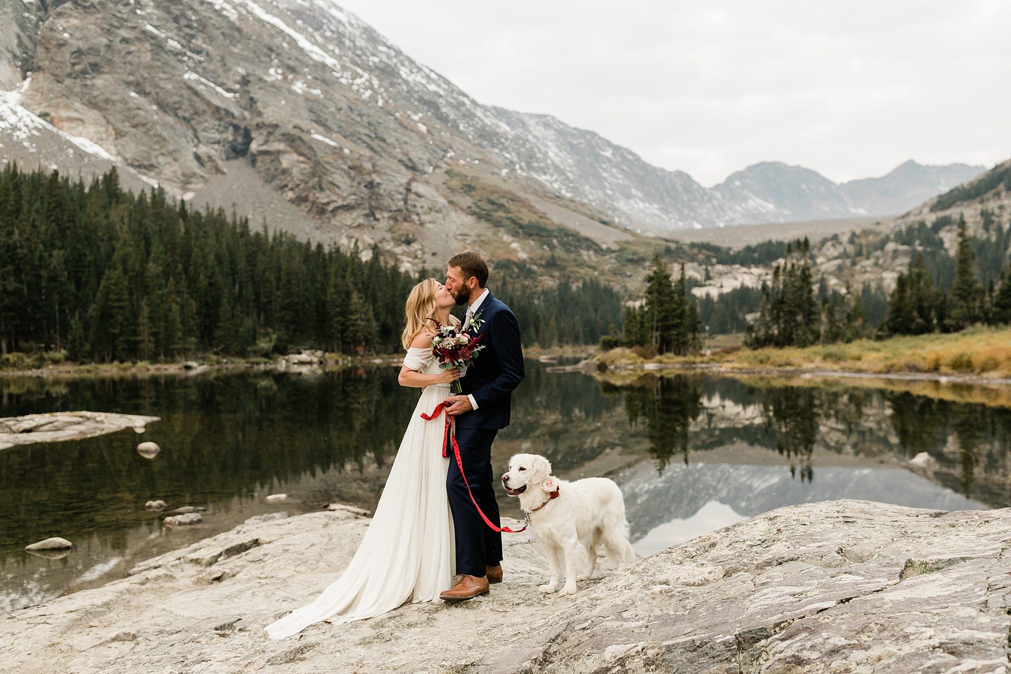 A couple kisses in front of Blue Lakes during their elopement in Colorado
