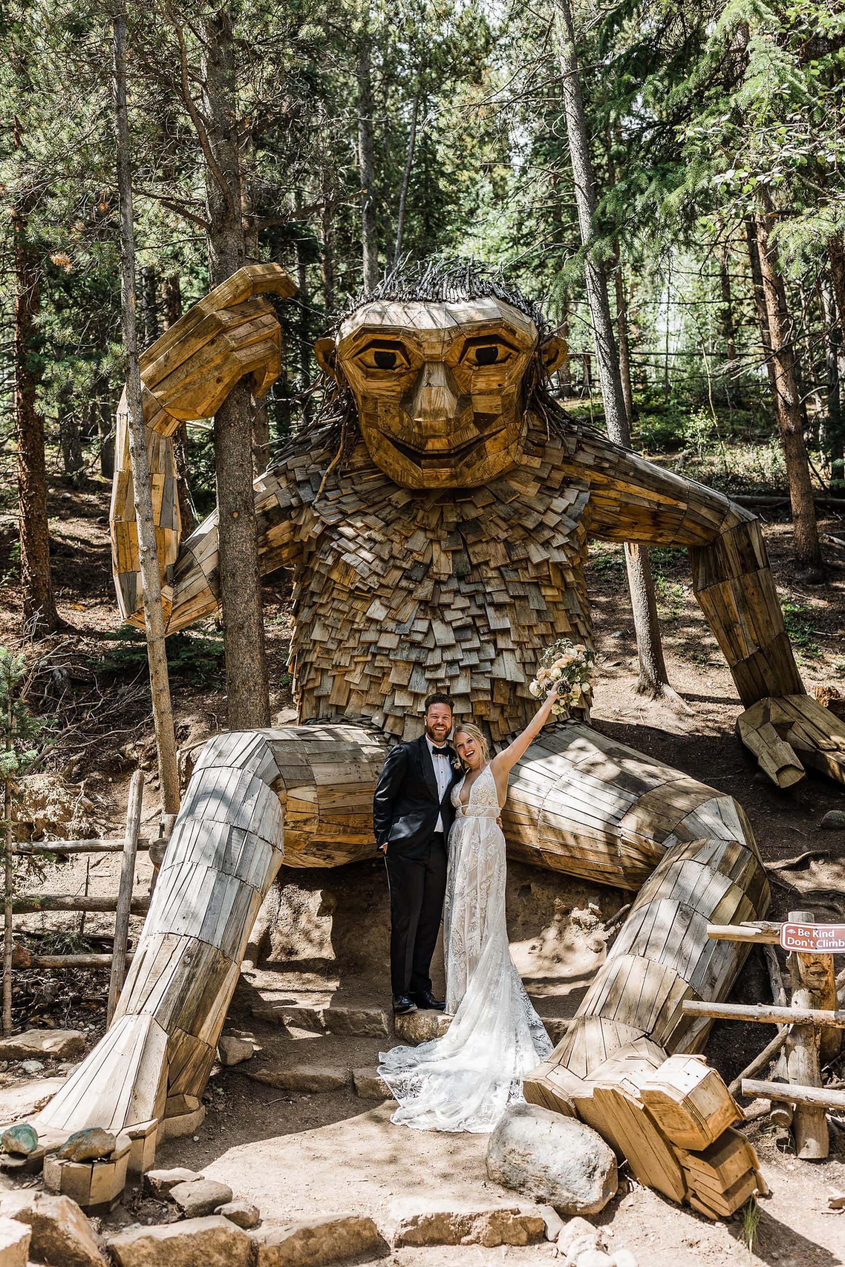 A newly married couple poses in front of Isak Heartstone in Breckenridge