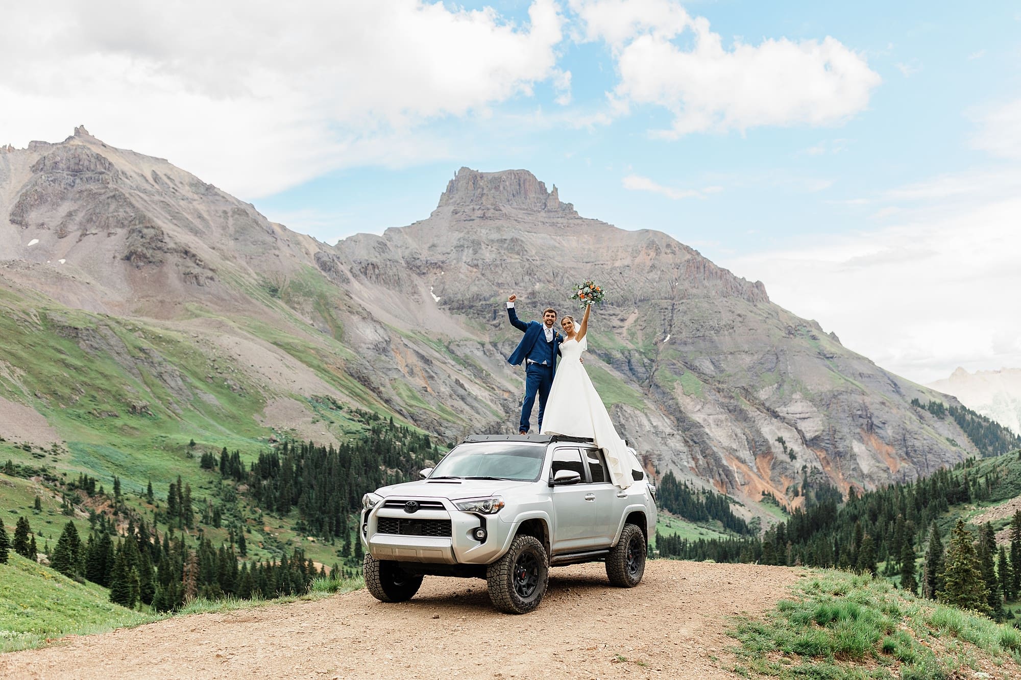 A couple stands on top of an off-roading vehicle in Ouray