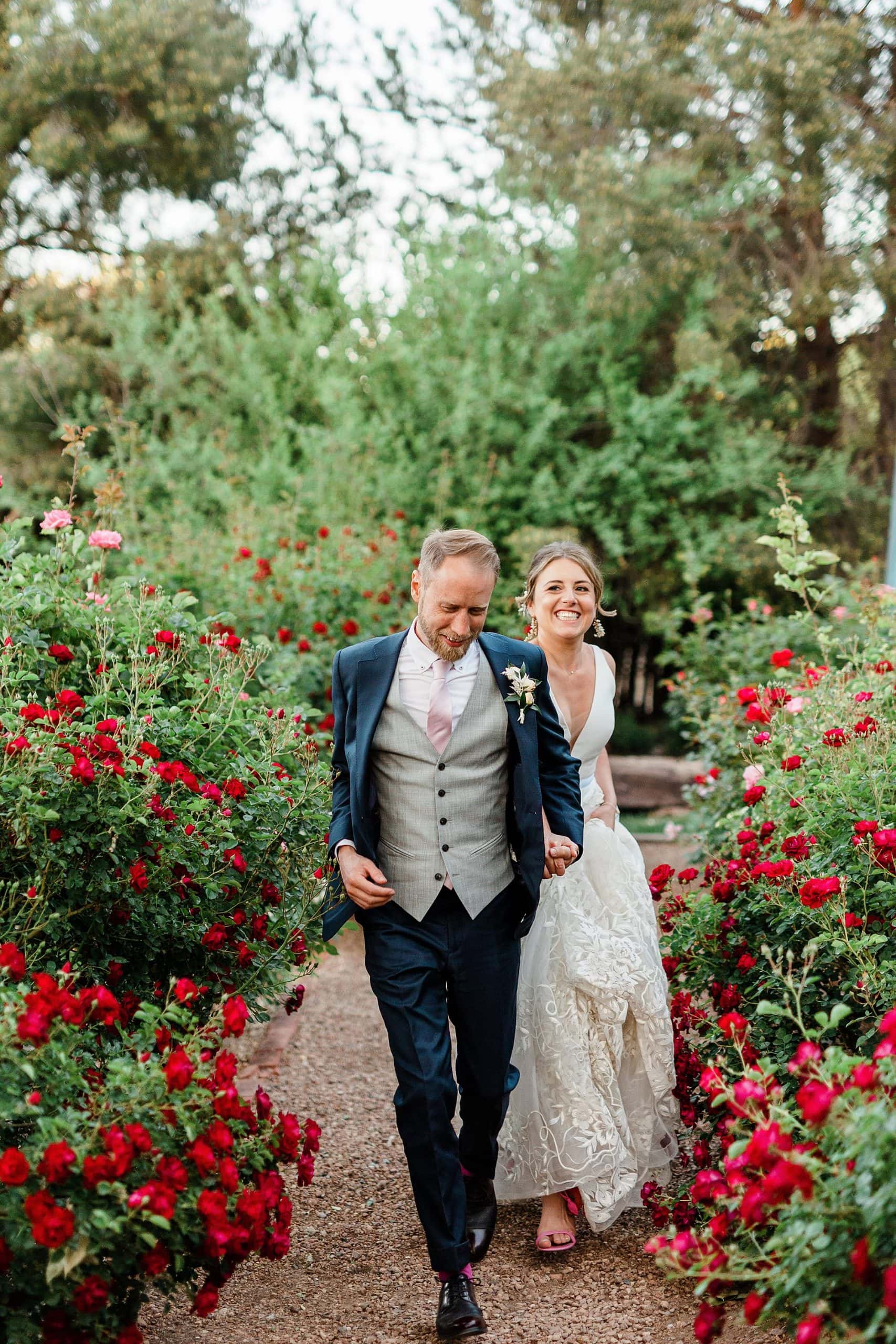 A couple runs through a rose garden in New Mexico for their elopement photos