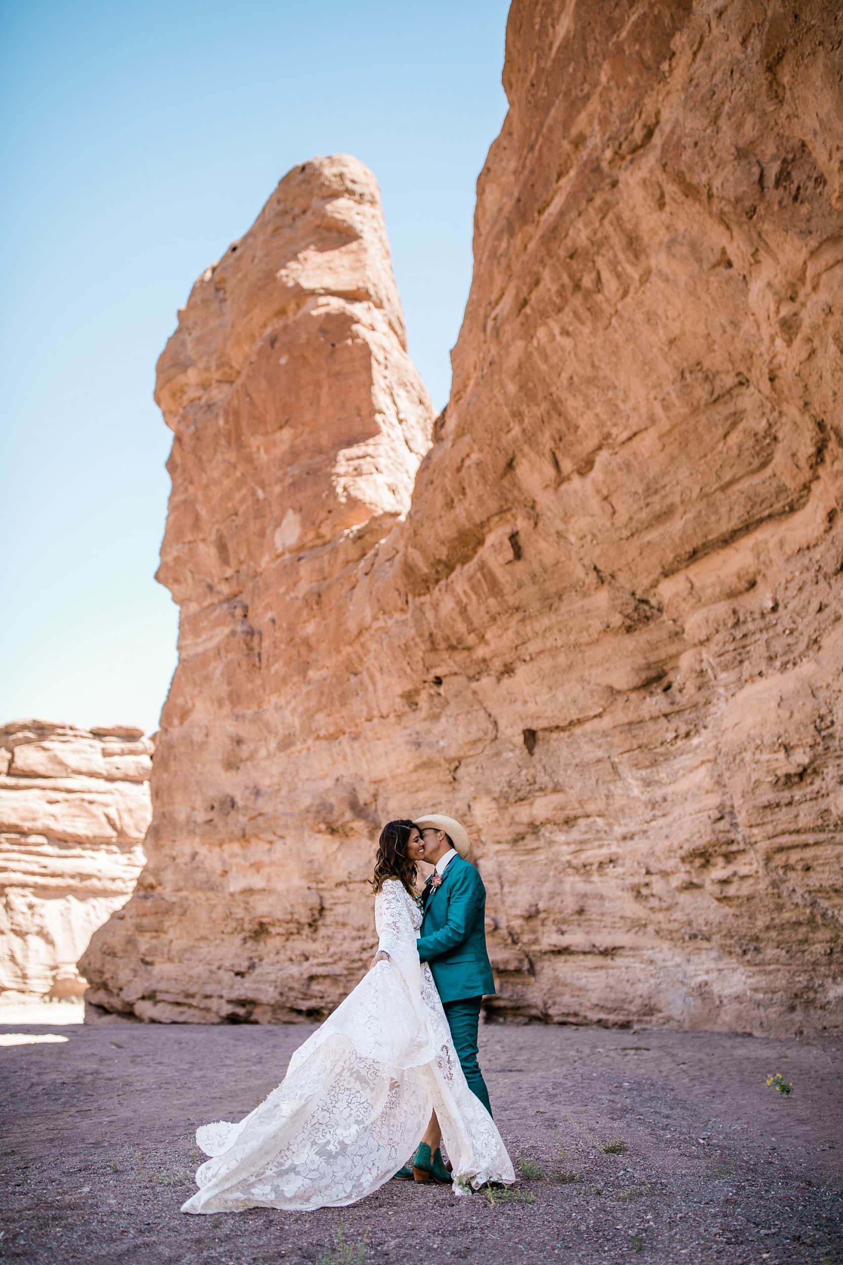 A couple kisses in front of rock formations in Albuquerque during their elopement