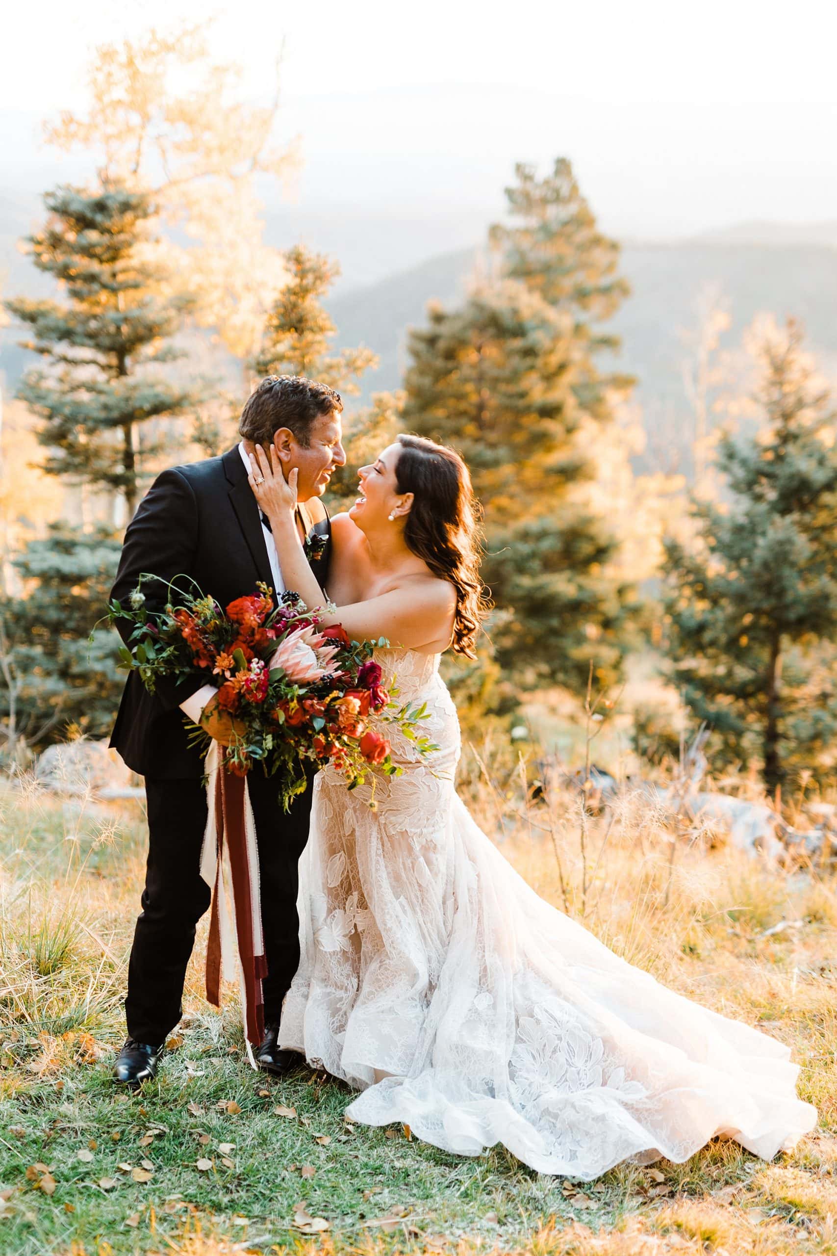 A couple celebrates their Santa Fe elopement in a forest while holding florals