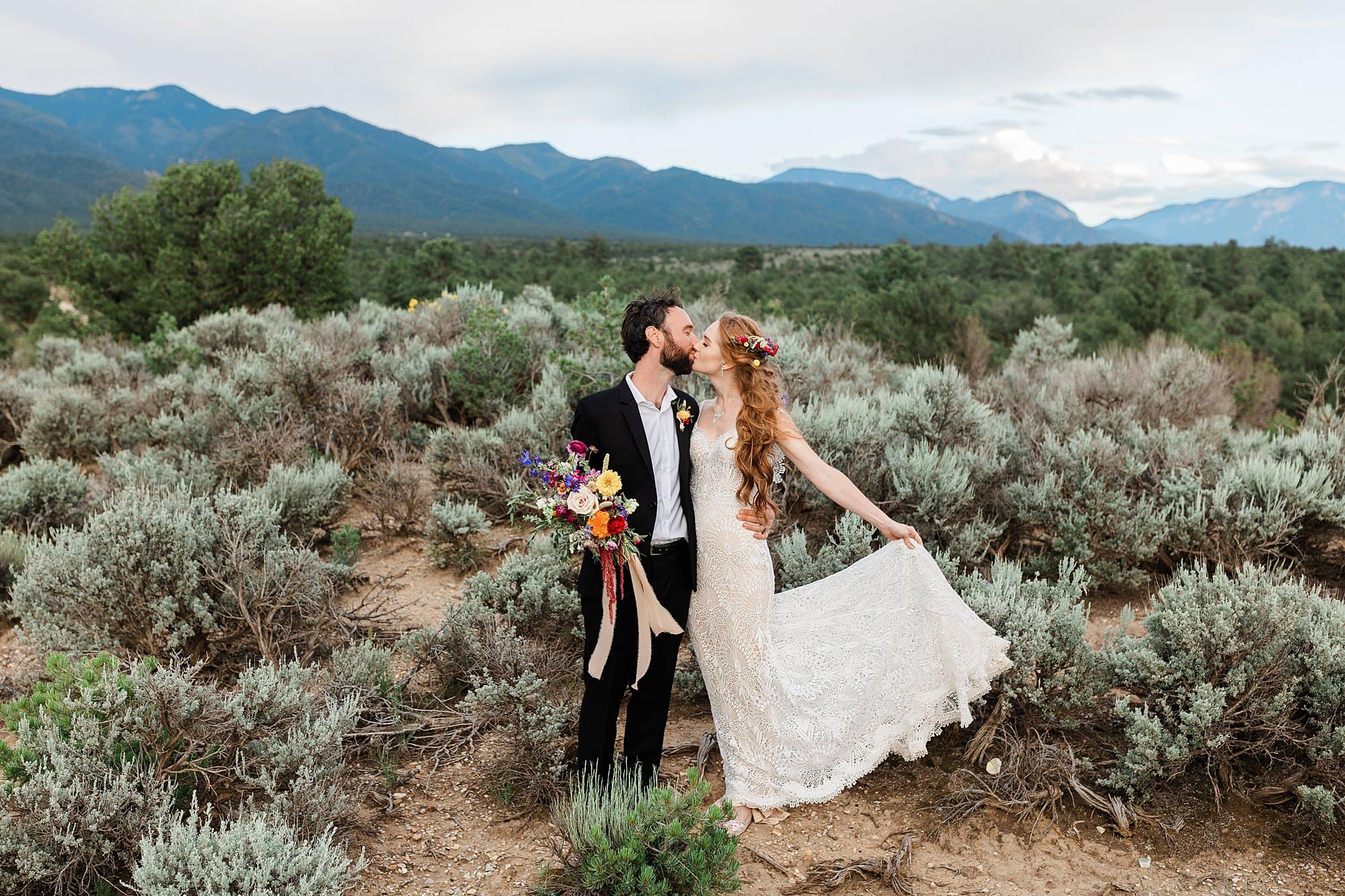 A couple kisses on a goji berry farm during their intimate wedding in Taos, New Mexico