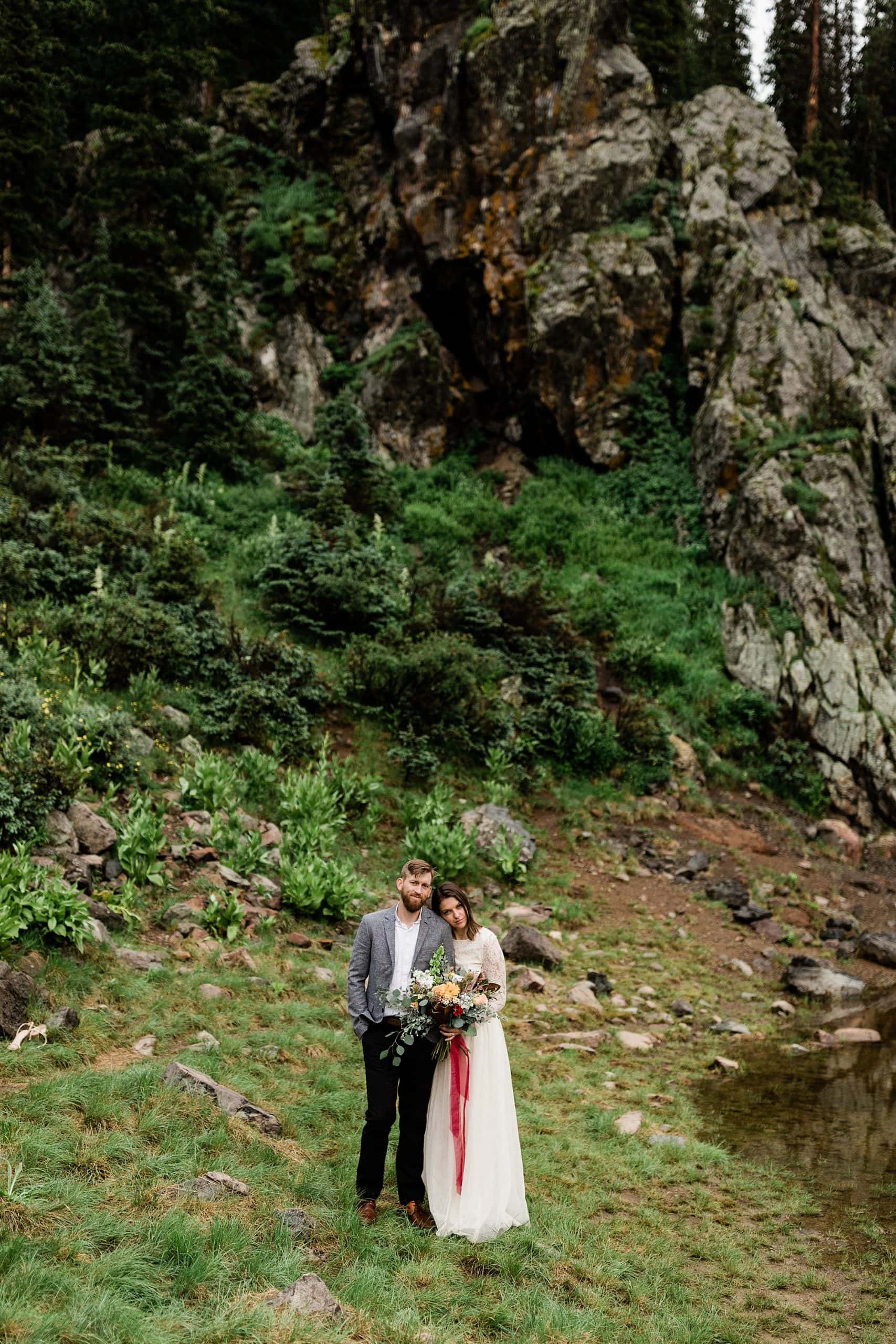 A bride rests her head on her groom in the mountains of Taos